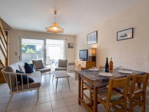 cocina y sala de estar con mesa y sillas en Villa Locmariaquer, 3 pièces, 4 personnes - FR-1-477-36, en Locmariaquer