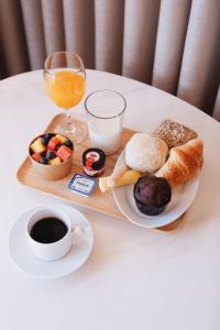 un vassoio con prodotti per la colazione e un bicchiere di succo d'arancia di ORM Carregal Apartment a Porto