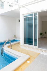 uma piscina num quarto com uma grande janela em Casa Medina em Chetumal