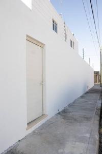 a white building with a door on the side of it at Casa Medina in Chetumal