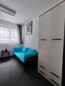 ein Wohnzimmer mit einem blauen Sofa und einem Schrank in der Unterkunft Vibe House Prague in Prag