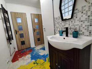 a bathroom with a sink and a colorful floor at Vibe House Prague in Prague