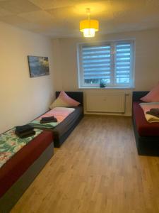 a room with two beds and a couch and a window at Cosy Apartment I 5Beds I Near VW in Glauchau