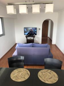 sala de estar con sofá azul y TV en Diagonal depto 3 ambientes zona centro en Mar del Plata