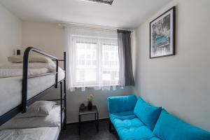 ein Schlafzimmer mit einem blauen Sofa und einem Etagenbett in der Unterkunft Vibe House Prague in Prag