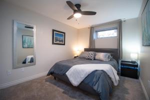 een slaapkamer met een bed en een plafondventilator bij Bright private suite near Departure Bay beach in Nanaimo