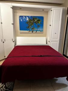 a bedroom with a red bed with a painting on the wall at Our Beach Escape in Daytona Beach