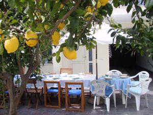 カブラスにあるB&B Solanasのレモンの木の下にダイニングテーブルと椅子