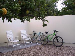 two bikes parked next to two chairs and a wall at B&B Solanas in Càbras