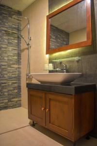 un baño con lavabo y espejo en ARA Beach Resort Mirissa, en Mirissa
