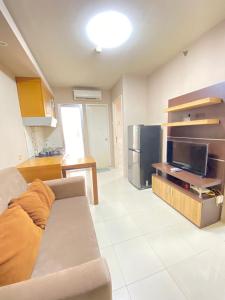 - un salon avec un canapé et une télévision dans l'établissement Sewa Apartemen Kalibata City by The Best, à Jakarta