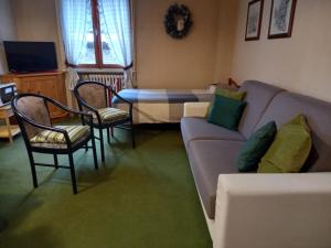 ein Wohnzimmer mit einem Sofa und einem Tisch in der Unterkunft Appartamento Marco in Bormio