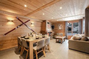 - une salle à manger avec une table et un canapé dans l'établissement Chalet Le R'Posiao, à Morzine