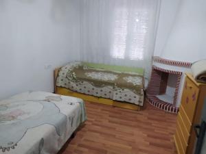 a room with two beds in a room with a window at Amplio piso en centro con balcón in Cuenca