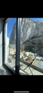 ventana con vistas a una mesa y sillas en CP High floor luxury studio, en Gibraltar
