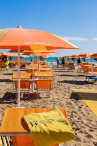 a beach with chairs and umbrellas on the sand at Hotel Continental in Tortoreto Lido