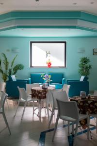 a dining room with blue walls and tables and chairs at Hotel Continental in Tortoreto Lido
