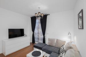 ein Wohnzimmer mit einem Sofa und einem TV in der Unterkunft Black&White in Krakau