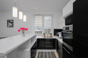 a white kitchen with a vase of flowers on the counter at Black&White in Krakow