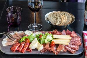 a plate of meats and cheese and a glass of wine at Pointe Isabelle in Chamonix