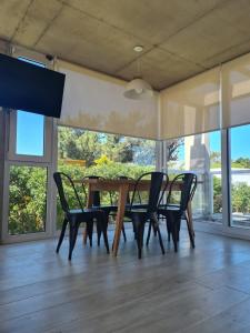 comedor con mesa de madera y sillas en Complejo 42 en Balneario Mar Azul