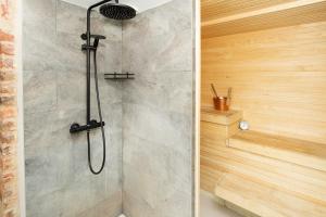 a shower with a glass door in a bathroom at Old Town Luxury apartment with sauna in Tartu