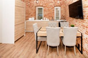a dining room with a wooden table and chairs at Old Town Luxury apartment with sauna in Tartu