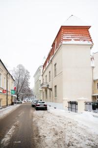 a snowy street with cars parked on the side of a building at Old Town Luxury apartment with sauna in Tartu