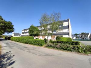 a building with green bushes next to a street at Appartement Fouesnant, 2 pièces, 4 personnes - FR-1-481-55 in Fouesnant