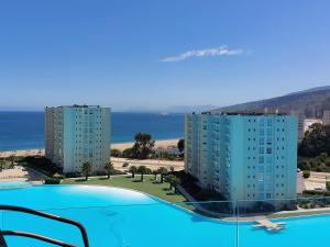 uitzicht op twee appartementsgebouwen en een zwembad bij Departamento Papudo Laguna in Papudo