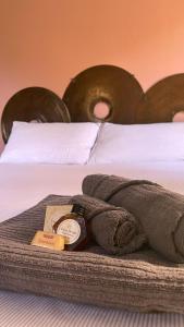 a bed with a towel and a clock on it at Agriturismo Agagin in Agaggio Inferiore