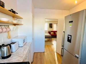 una cucina con frigorifero e piano di lavoro di St Albans Village Studios by DC London Rooms a Londra