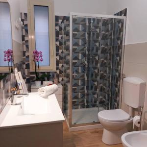 a bathroom with a shower and a toilet and a sink at Blue Sicily Apartment in Roccalumera