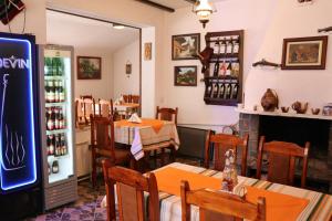 un restaurant avec des tables, des chaises et un réfrigérateur dans l'établissement Хотел Феникс, à Chepelare