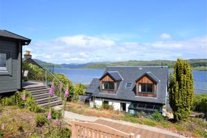 a house on the shore of a body of water at The Neuk in Tighnabruaich