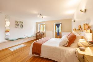 um quarto com uma cama grande e piso em madeira em Le Fournia em Grandrif