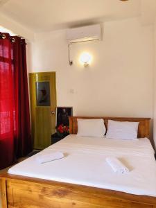 a bedroom with a large bed with two white pillows at Nilan Villa in Koggala