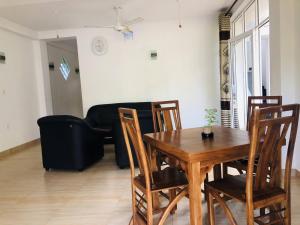 a living room with a wooden table and chairs at Nilan Villa in Koggala