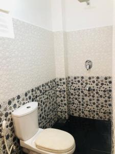 a bathroom with a toilet and a shower at Nilan Villa in Koggala