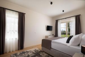 um quarto com uma cama e uma grande janela em Villa Estelle by ILC (Istria Luxury Collection) em Brtonigla