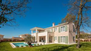 a large house with a swimming pool in a yard at Villa Estelle by ILC (Istria Luxury Collection) in Brtonigla