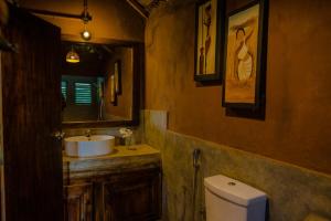 a bathroom with a toilet and a sink and a mirror at Gaga Bees Yala in Tissamaharama