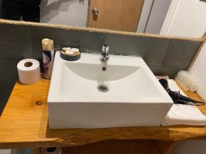 lavabo blanco en una encimera de madera en el baño en Dpto tipo cabaña en Pucón, en Pucón