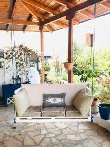 a white couch hanging from a porch with pillows at Chrysa's Holiday Apartment in Pylos
