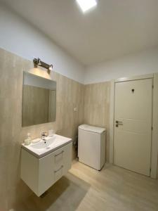 een badkamer met een wastafel, een toilet en een spiegel bij Q Apartament Loft place near Palas Mall in Iaşi