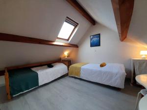 Schlafzimmer im Dachgeschoss mit 2 Betten und einem Fenster in der Unterkunft Appartement Saint-Philibert, 3 pièces, 4 personnes - FR-1-477-187 in Saint-Philibert