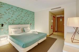 um quarto com uma cama com uma parede azul em Dfm Happy Days C - Funchal em Funchal