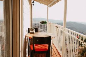 a table on a balcony with a view of the mountains at צימר נור החרמון in Majdal Shams