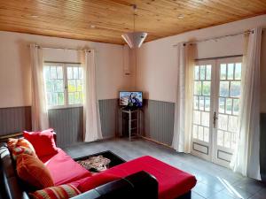een woonkamer met een rode bank en een tv bij Les Durantas in Cilaos