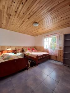 een kamer met 2 bedden en een houten plafond bij Les Durantas in Cilaos